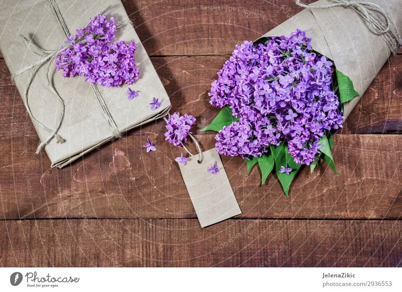 Gift and bouquet of lilacs on a wooden table Beautiful Summer Decoration Desk Table Feasts & Celebrations Valentine's Day Mother's Day Easter Wedding Birthday