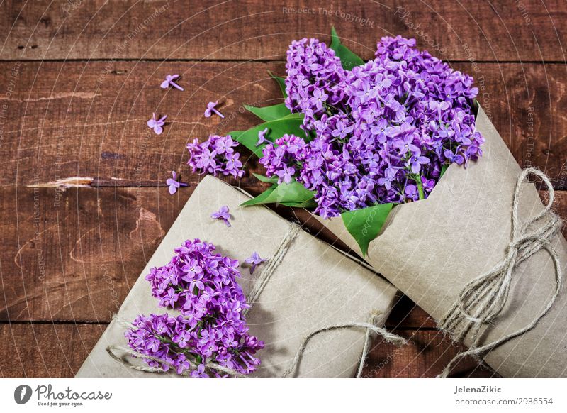 Gift and bouquet of lilacs on a wooden table Beautiful Summer Decoration Desk Table Feasts & Celebrations Valentine's Day Mother's Day Easter Wedding Birthday