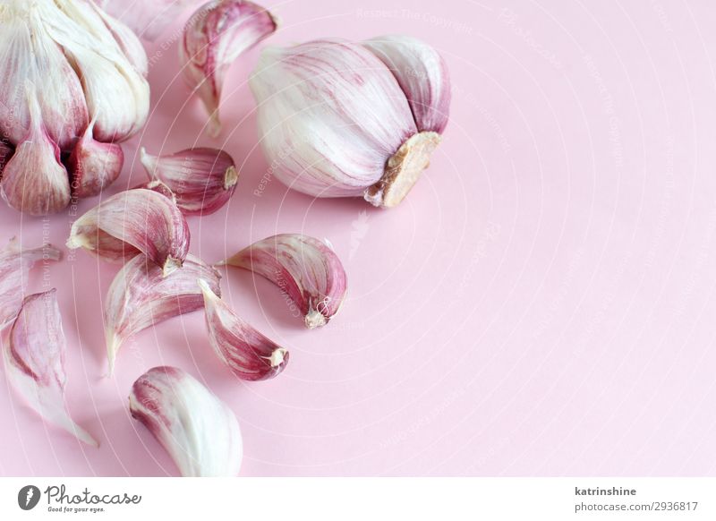 Fresh garlic on a light pink background Vegetable Herbs and spices Vegetarian diet Decline Garlic bulb ingrerient Clove food health healthy Organic Raw