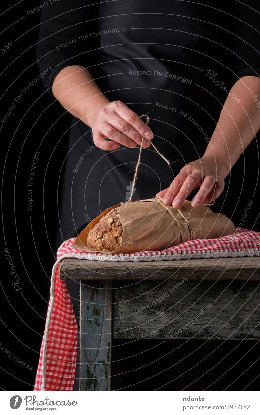 girl in black clothes wraps a whole baked loaf of bread Bread Roll Nutrition Eating Breakfast Table Kitchen Rope Woman Adults Hand 1 Human being 18 - 30 years