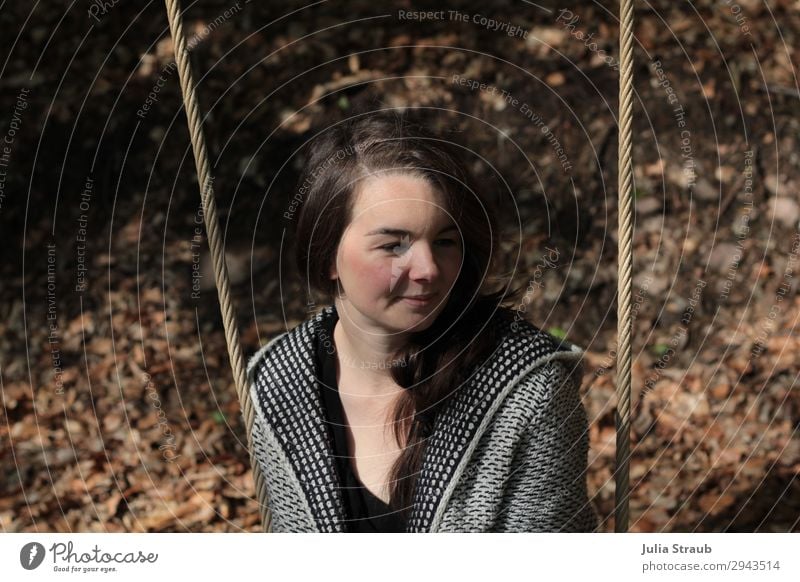 Woman with long brown hair sits on a swing in the forest in autumn Feminine 1 Human being 30 - 45 years Adults Nature Earth Summer Leaf Forest Cardigan Brunette