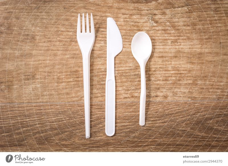 Disposable plastic cutlery on wooden table. Top view Kitchen Plastic tableware Crockery Recycling empty Environment Fork garbage Group Industrial Birthday