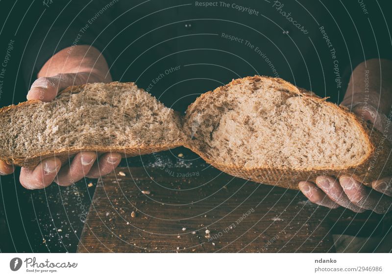 broken off crusty bread baked from rye flour Bread Nutrition Table Kitchen Cook Human being Hand Fingers Wood Make Dark Fresh Brown Black White Tradition grain