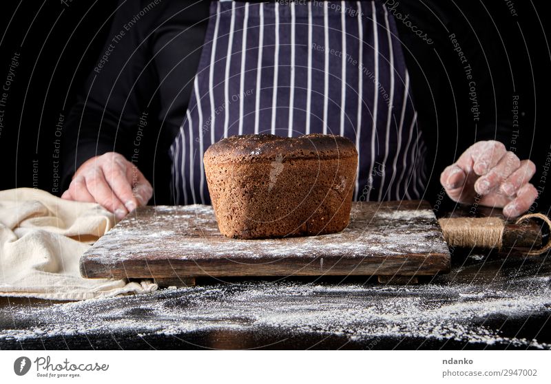 baked rye bread on a brown wooden board Bread Nutrition Eating Lunch Dinner Diet Table Kitchen Cook Man Adults Hand Wood Make Dark Fresh Delicious Natural Brown