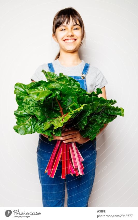 Happy girl holding a bunch of swiss chard Vegetable Nutrition Vegetarian diet Diet Joy Child Leaf Smiling Fresh Natural Green Red White rainbow chard Vegan diet