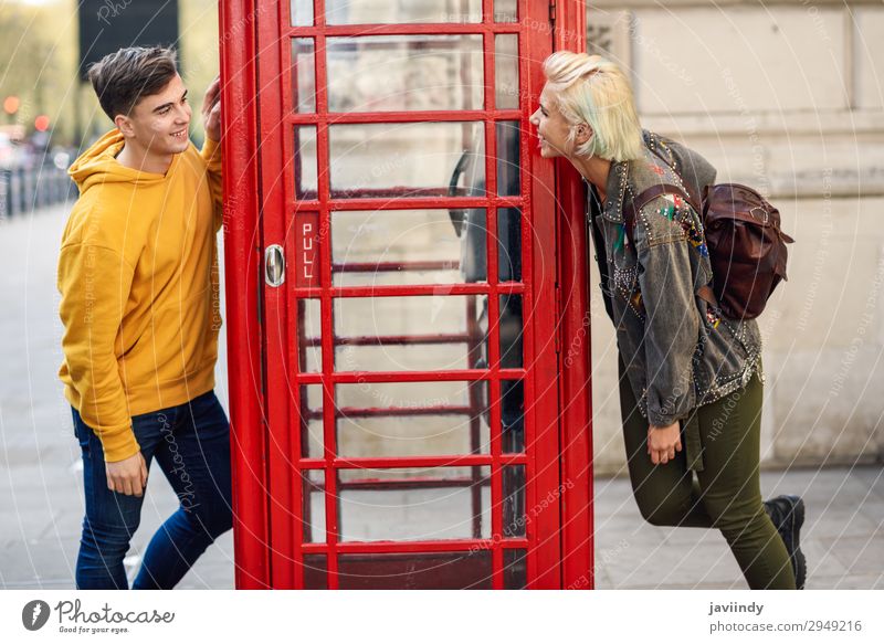 Young couple of friends near a classic British red phone booth Lifestyle Vacation & Travel Tourism Sightseeing Telephone Human being Masculine Feminine