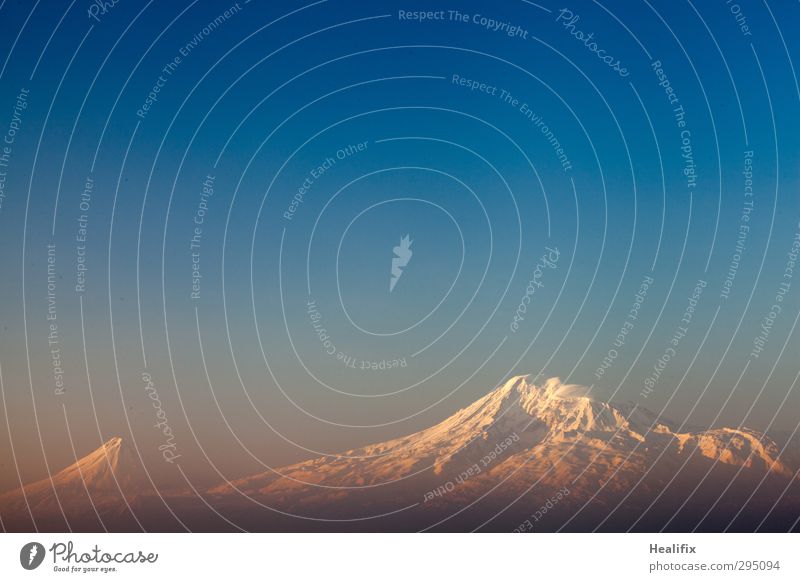 morning glory Landscape Air Sky Cloudless sky Beautiful weather Mountain Peak Snowcapped peak Volcano Illuminate Esthetic Large Infinity Warmth Blue Yellow