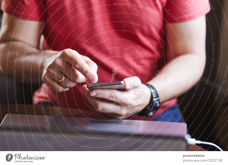 Man using smartphone working on laptop Lifestyle Desk Work and employment To talk Telephone Cellphone PDA Computer Notebook Screen Technology Internet