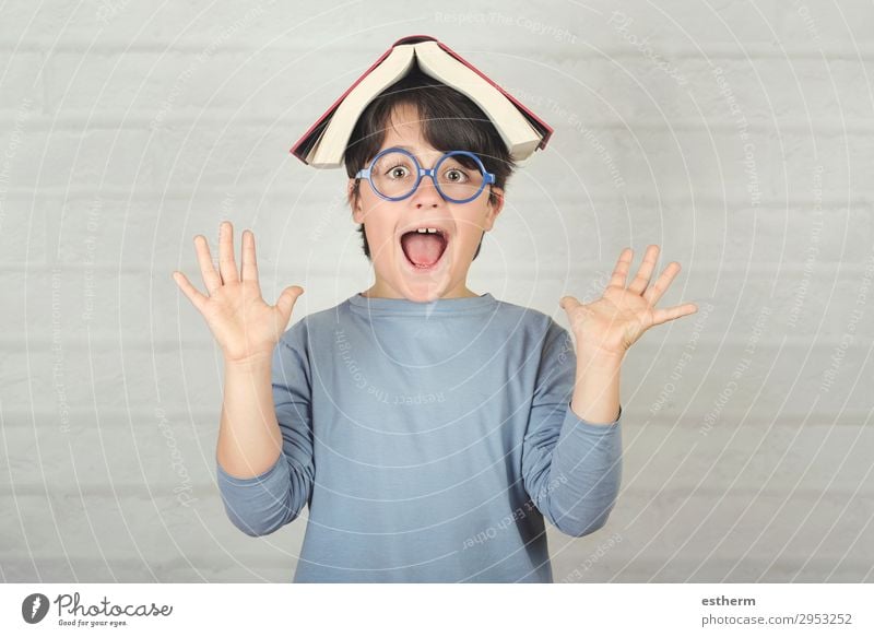 happy and smiling child with book on head Lifestyle Joy Playing Reading Education School Schoolchild Student Human being Masculine Child Toddler Infancy 1