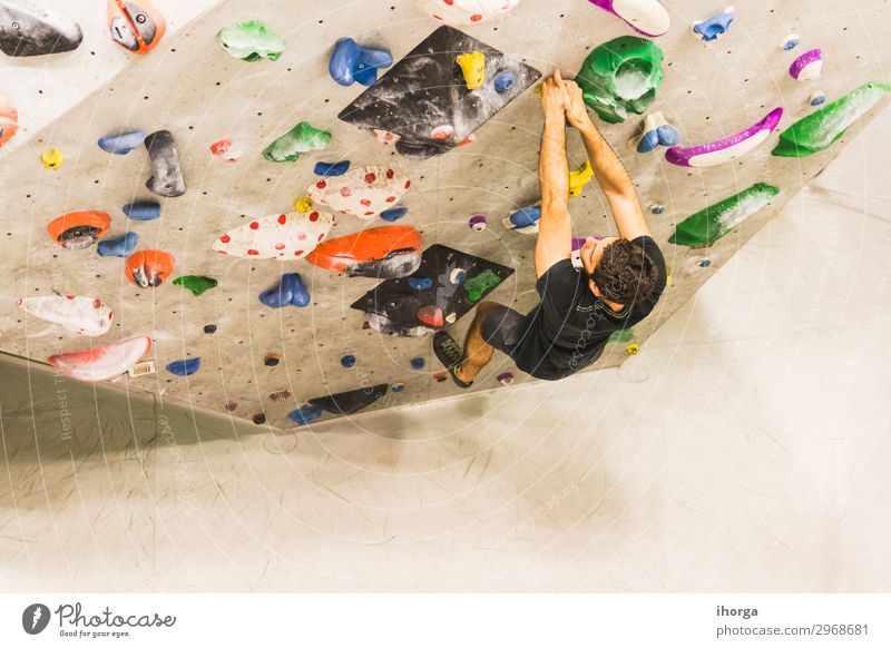 Man practicing rock climbing on artificial wall indoors. Lifestyle Joy Leisure and hobbies Sports Climbing Mountaineering Hiking Adults 1 Human being