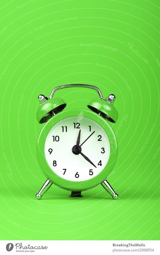 Close up one alarm clock over green background Paper Clock Clock face Clock hand Alarm clock Metal Green timing Period of time Retro Colour photo Multicoloured