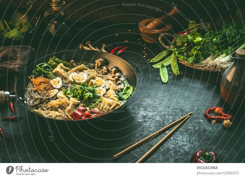 Asian food background with wok pan with vegetarian  korean hot pot and chopsticks on dark rustic kitchen table background, top view. Copy space. asian