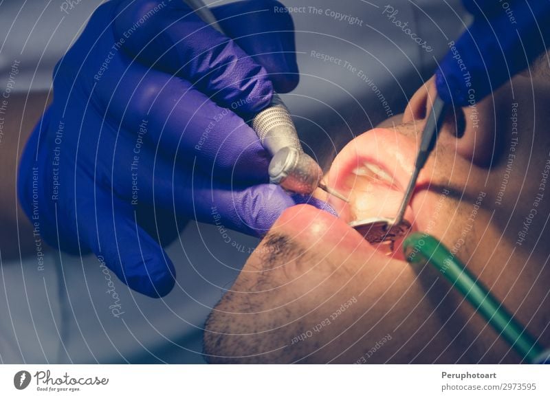 Seated young man is being examined his teeth by a dentist. Health care Medical treatment Medication Work and employment Profession Doctor Hospital Industry