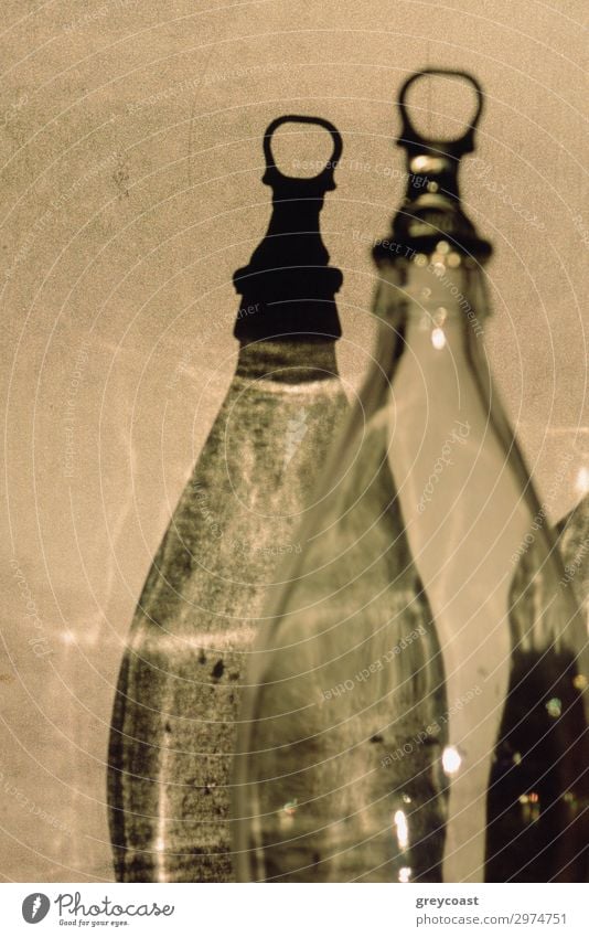 A fragment of a transparent empty bottle ant its more graphic shadow on a light wall Bottle Beautiful Thin Twin Bottle lid Fragment sharpness Monochrome