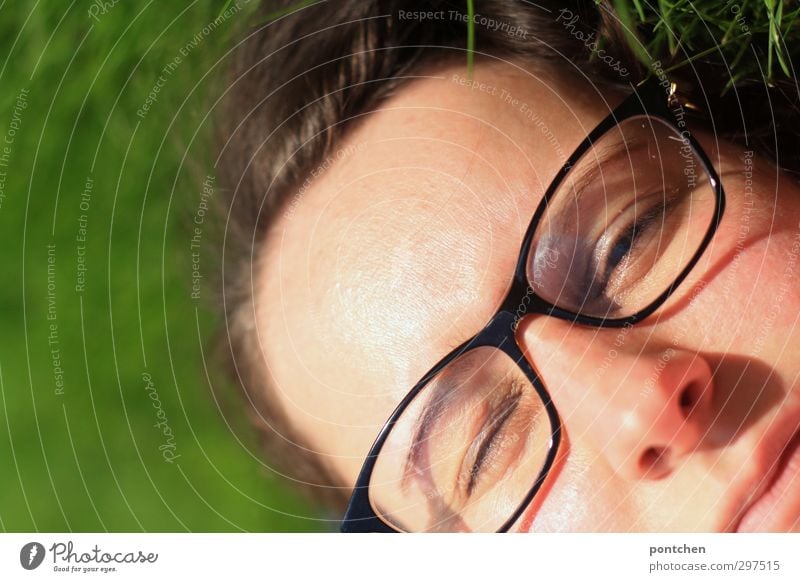 Face of a woman with glasses in the grass. Eyes half closed. Blinking in the sunlight. Recovering and relaxing Feminine Young woman Youth (Young adults) Woman