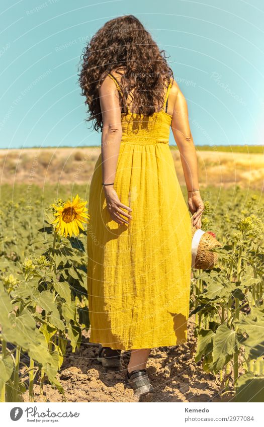 Young woman with yellow dress and hat walks in the countryside. Lifestyle Style Design Beautiful Hair and hairstyles Wellness Harmonious Relaxation Calm