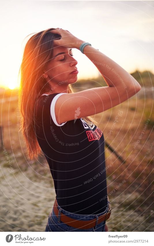 Portrait of a young woman enjoying the sunlight in summer Lifestyle Joy Beautiful Contentment Leisure and hobbies Vacation & Travel Summer Sunbathing Beach