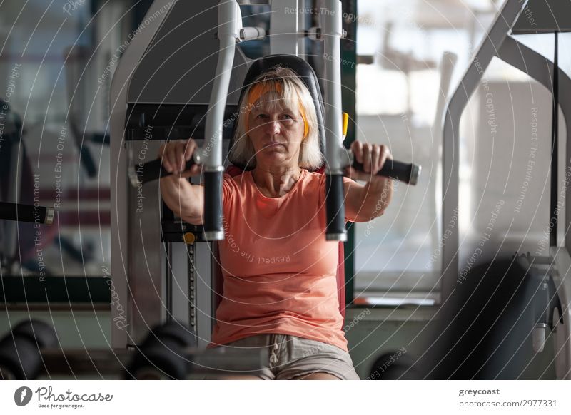 An older woman practices exercises on a fitness trainer Sports Fitness Sports Training Sporting Complex Human being Feminine Woman Adults 1 45 - 60 years Blonde