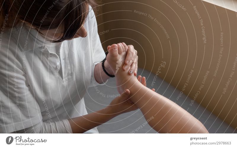 A small baby foot, being held and inspected by a doctor Child Doctor Human being Masculine Feminine Baby Boy (child) Young woman Youth (Young adults) Woman