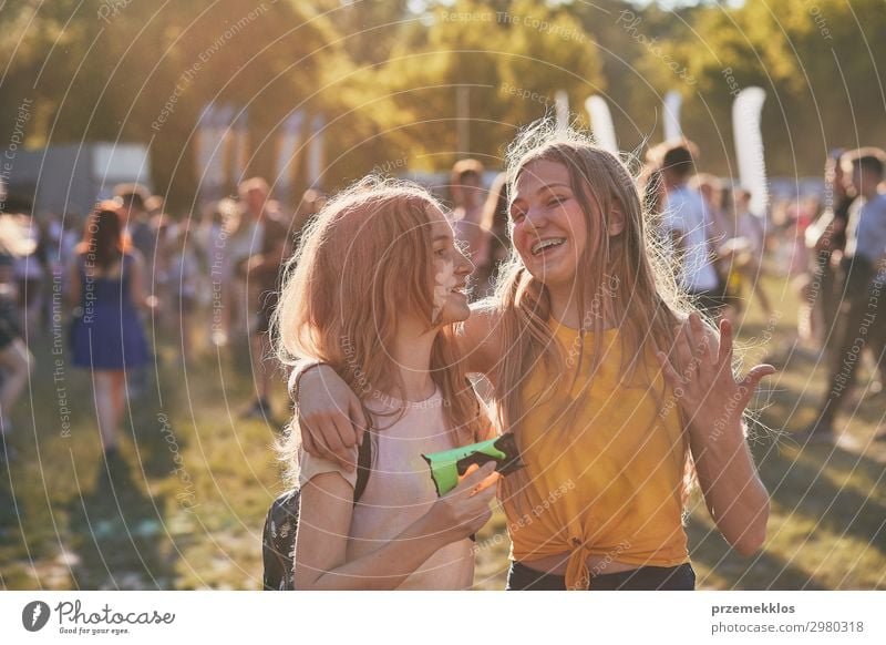 Portrait of happy smiling young girls with colorful paints on faces and clothes. Two friends spending time on holi color festival Lifestyle Style Joy Happy