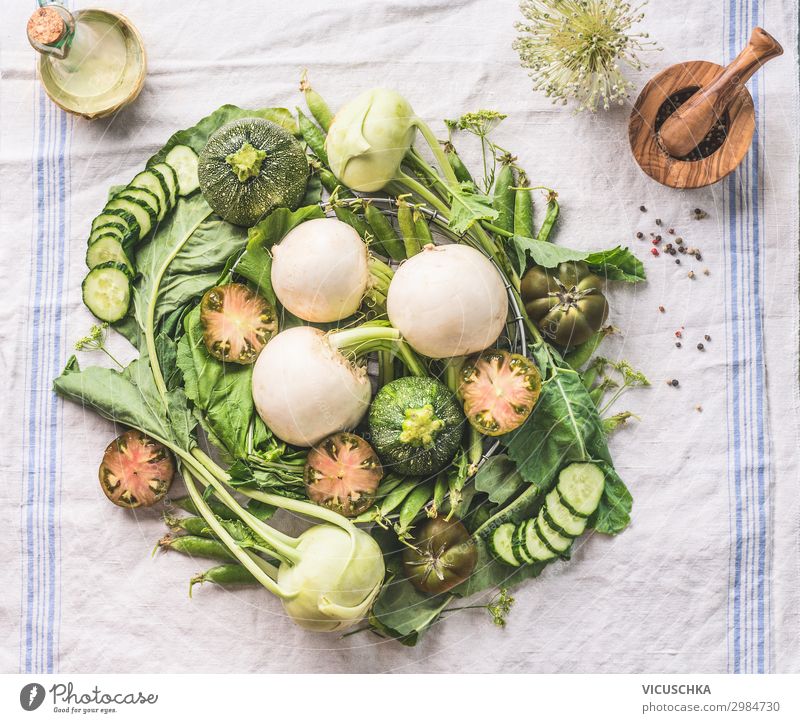 Various green organic seasonal vegetables from local farm market on light kitchen table , top view. Healthy vegetarian eating and cooking concept. Clean food