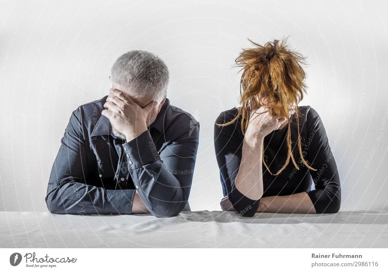 A man and a woman sit at a table, they seem depressed and silent Human being Masculine Feminine Woman Adults Man 2 Sit Argument Sadness Wait Emotions Grief