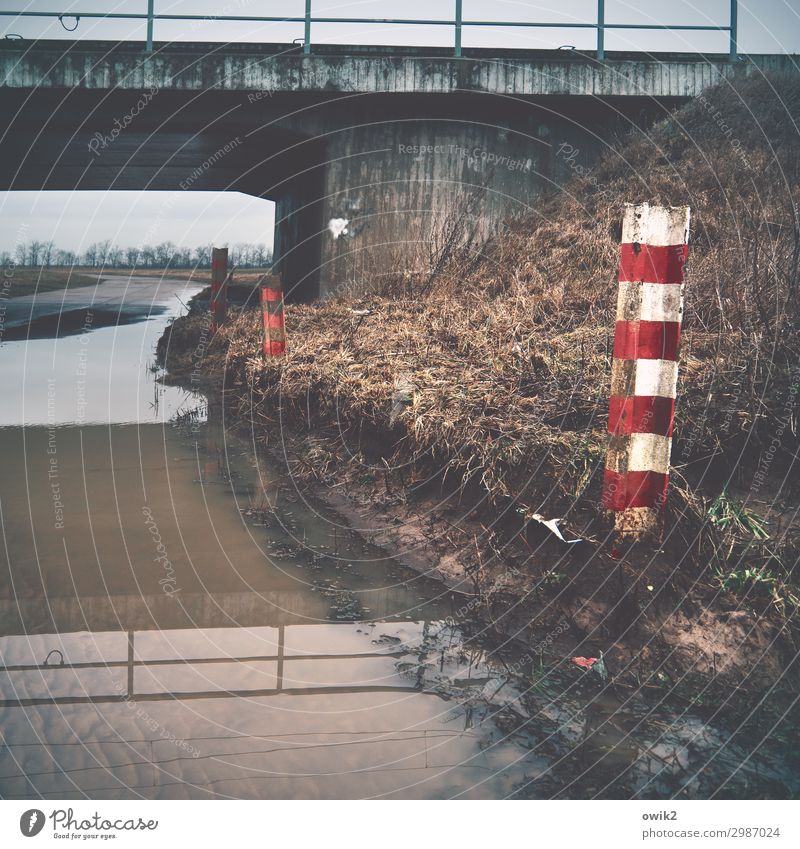 Clear height Environment Nature Water Sky Clouds Horizon Grass Bushes Teltow-Fläming district Germany Bridge Countdown marker Gloomy Puddle Warning colour