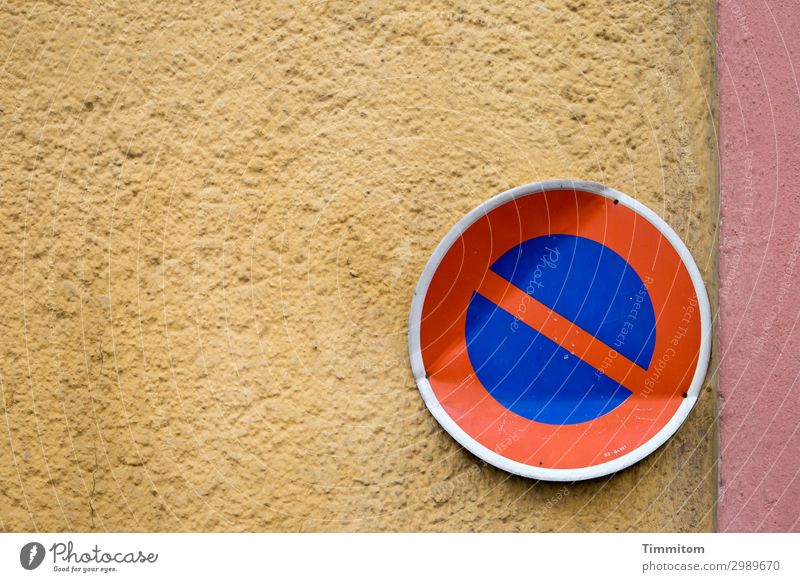 Somewhat bent sign on house wall Road sign Prohibition sign Clearway corrupted Bend colored Shadow Stone Metal Signs and labeling Deserted Exterior shot