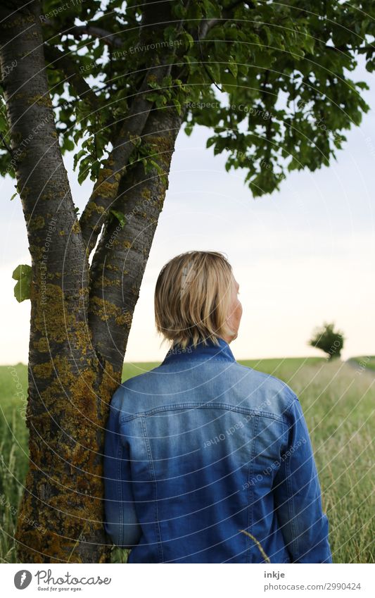 Woman leaning against tree trunk back view Lifestyle Leisure and hobbies Trip Summer To go for a walk Promenade Footpath Feminine Young woman