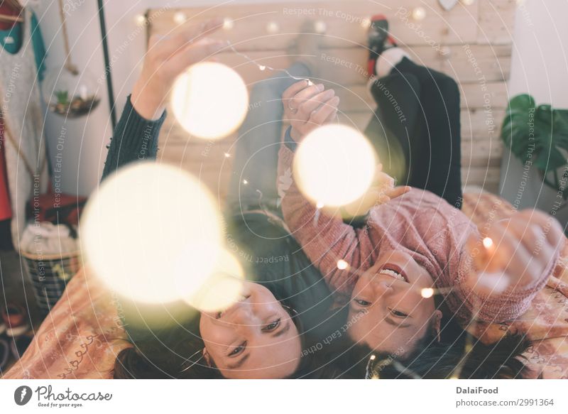 girls playing with christmas lights in bed Christmas & Advent Friendship Family & Relations Happy 18 - 30 years New Year Feasts & Celebrations Home Winter Woman