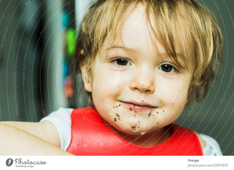 portrait adorable child eating chocolate sponge cake attribute baby background bib boy brown candy childhood cute delicious desert dessert dirty fat flavour