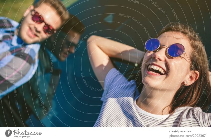 Young couple lying on the windshield Lifestyle Style Happy Beautiful Relaxation Vacation & Travel Sunbathing Human being Woman Adults Man Couple Car Sunglasses