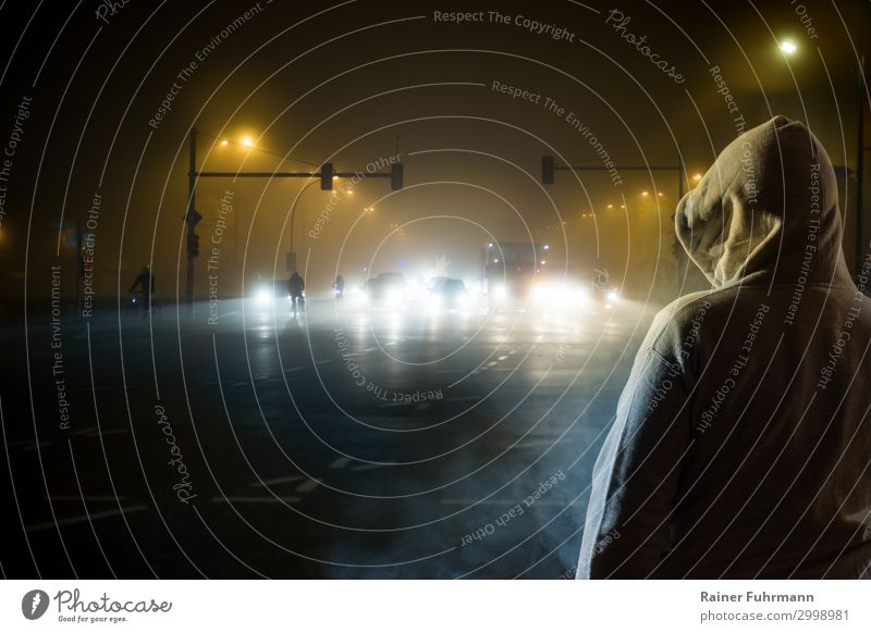 a man watches the traffic at night Human being Man Adults 1 Fog Town Capital city Populated "street Avenue Main Street" Transport Traffic infrastructure