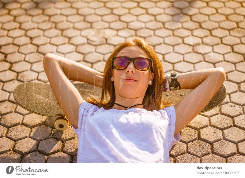 Young girl with a skateboard lying on the street in summer Lifestyle Style Joy Happy Beautiful Leisure and hobbies Summer Sports Human being Woman Adults