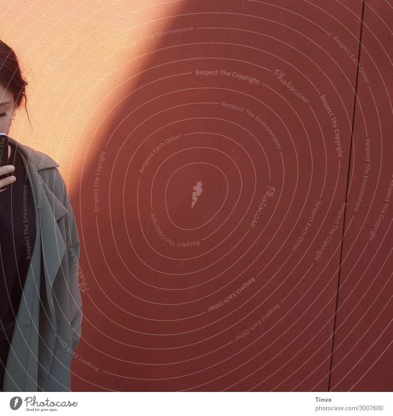 Woman with mobile phone in front of reddish wall Cellphone Young woman Youth (Young adults) 1 Human being 18 - 30 years Adults Wall (barrier) Wall (building)