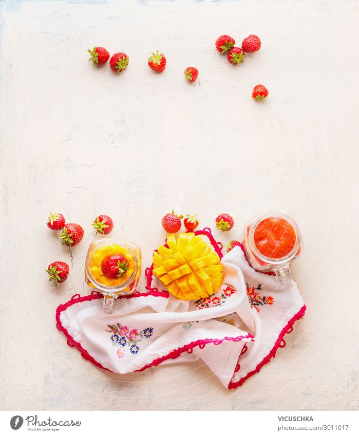 Healthy fruits and berries breakfast background. Glass jars with strawberries and mango smoothies on white table . Copy space healthy glass copy space detox