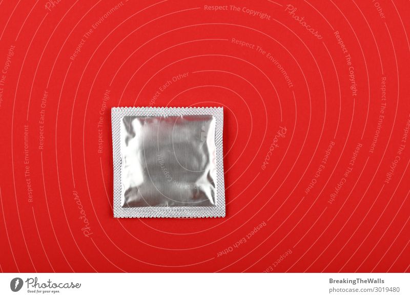 Close up one condom pack over red background Lifestyle Healthy Health care Medication Above Clean Red Protection Responsibility Caution Testing & Control Condom