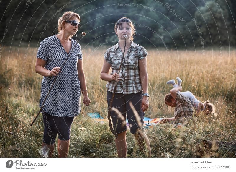 Women roasting a marshmallows over a campfire Lifestyle Joy Happy Relaxation Leisure and hobbies Playing Vacation & Travel Summer Summer vacation Child