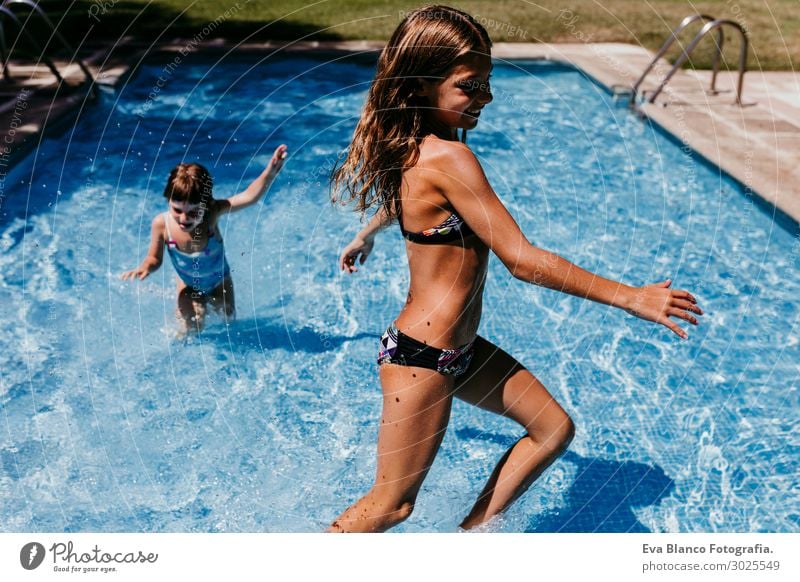 two beautiful sister kids at the pool playing. Summertime Drinking Juice Lifestyle Joy Swimming pool Playing Vacation & Travel Sun Sports Dive Child Human being