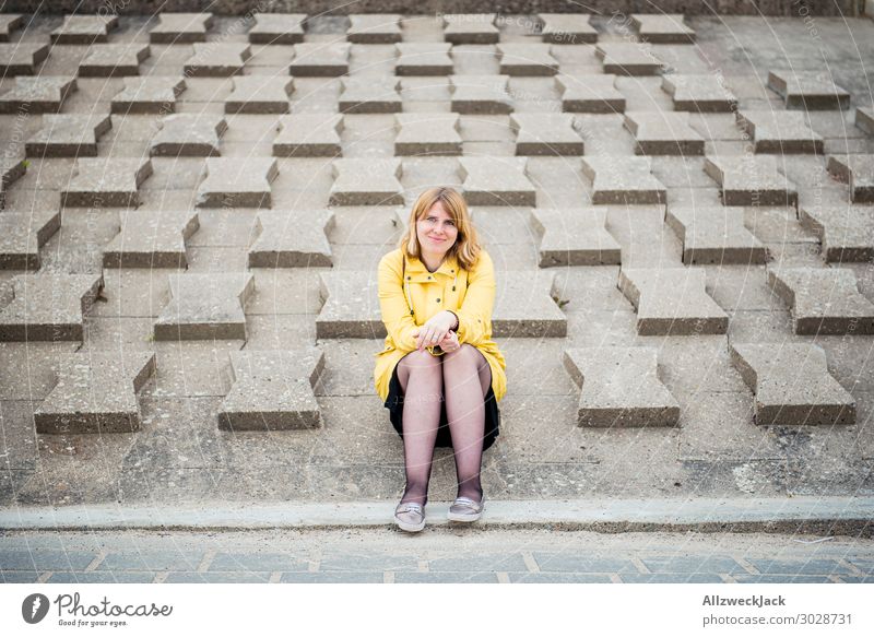 young woman in yellow raincoat sits on wave protection wall Germany Baltic Sea Coast Maritime Vacation & Travel Vacation destination Vacation photo Relaxation