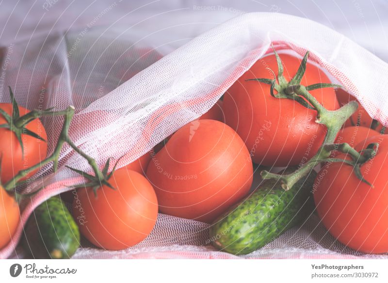 Fresh tomatoes and cucumbers in an eco bag close up. Food Vegetable Diet Lifestyle Healthy Eating Environment Packaging Package Modern Green Red White Colour