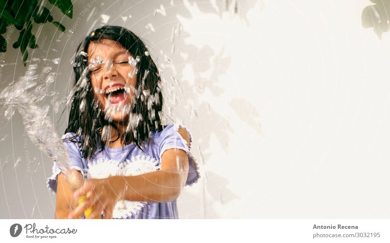 smiling girl with hose watering in summer day Lifestyle Joy Summer Child Human being Plant Tree Smiling Cool (slang) Fresh Wet 6s six years old Fig tree figs