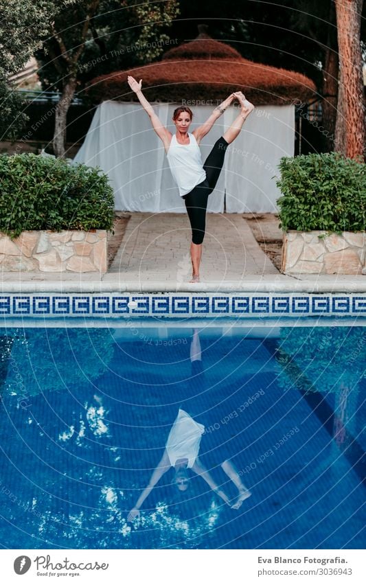 woman doing yoga by swimming pool. Yoga and mindfulness Lifestyle Beautiful Body Relaxation Calm Meditation Spa Swimming pool Leisure and hobbies