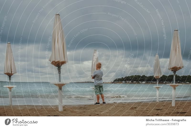 Child between beach umbrellas Vacation & Travel Tourism Summer Beach Ocean Human being Masculine Boy (child) Infancy 1 3 - 8 years Nature Water Clouds