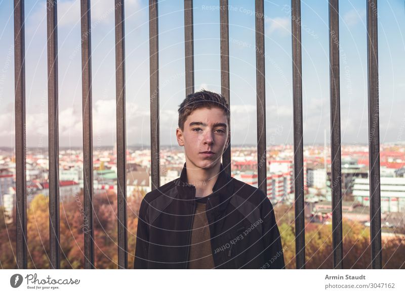 portrait of a smiling young man in front of bars and Berlin architecture autumn beautiful berlin border boy casual caucasian confident europe fun germany grid