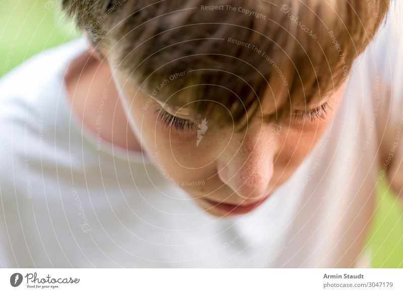 Portrait of a young man looking down, lost in thought portrait teenager serious thoughtful concentration boy male beautiful casual caucasian outdoor confident