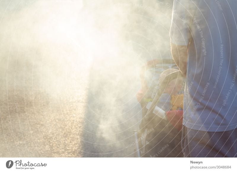 Father pushes baby in buggy through smoke in the sun Human being Baby Man Adults 2 Going Responsibility Dream Concern Fear of the future Stress Distress