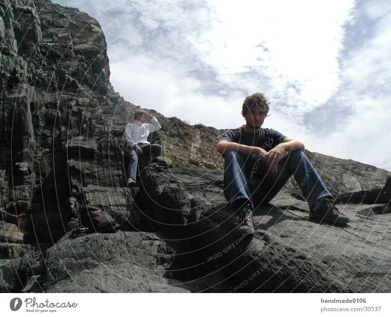 gery on the rocky coast Coast Portugal Man T-shirt Vacation & Travel Human being Rock Jeans Sit