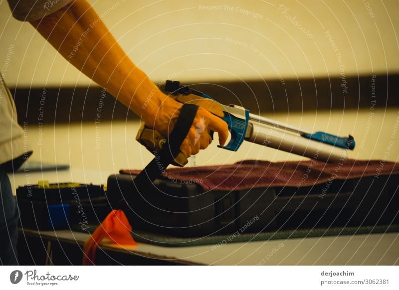 In training with the air pistol. The weapon is placed on a tray . You only see the hand, and the gun. Sports Handgun Hall Feminine Young woman