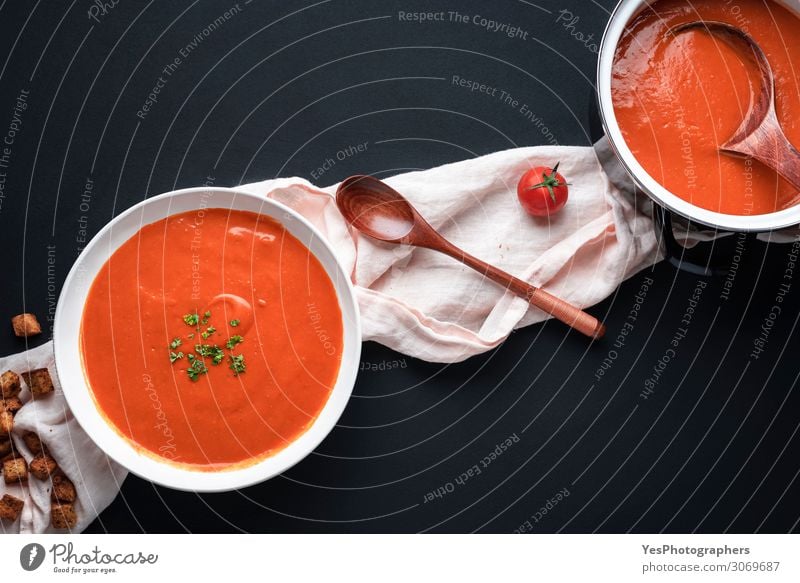 Tomato soup on black table. Healthy homemade soup Vegetable Soup Stew Herbs and spices Nutrition Lunch Dinner Vegetarian diet Diet Crockery Bowl Pot Spoon